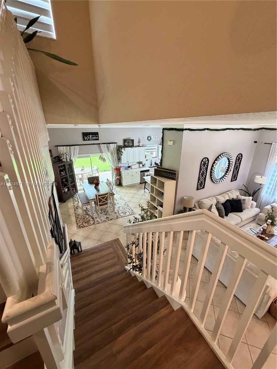 A high-angle view shows a staircase leading down to an open-concept living and dining area — 2116 NE 38th Rd # 2116, Homestead FL 33033, HOMESTEAD, FL