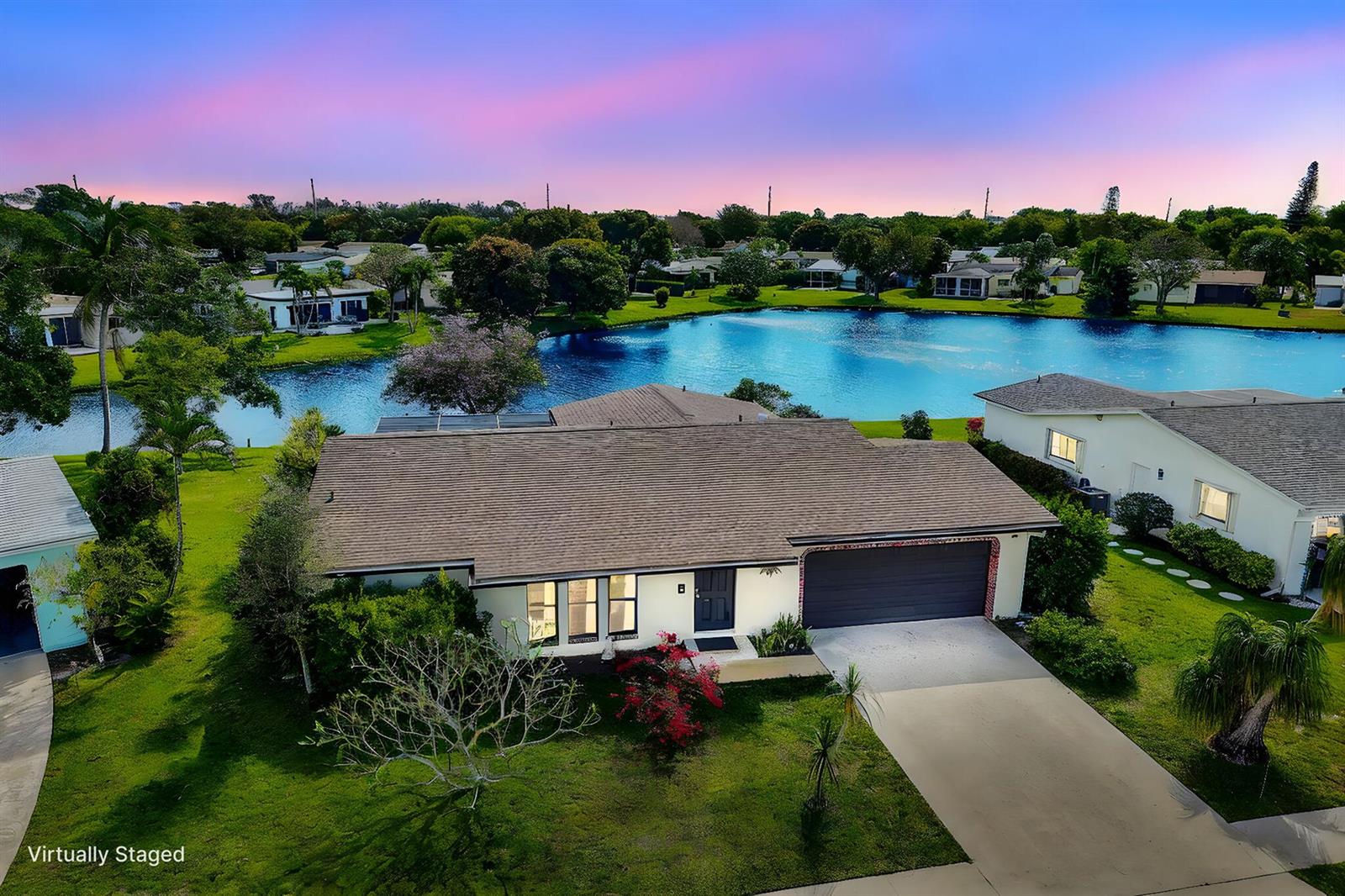 An aerial view of a single-story house with a garage and lawn beside a lake — 14592 Country Side Lane, Delray Beach FL 33484, DELRAY BEACH, FL