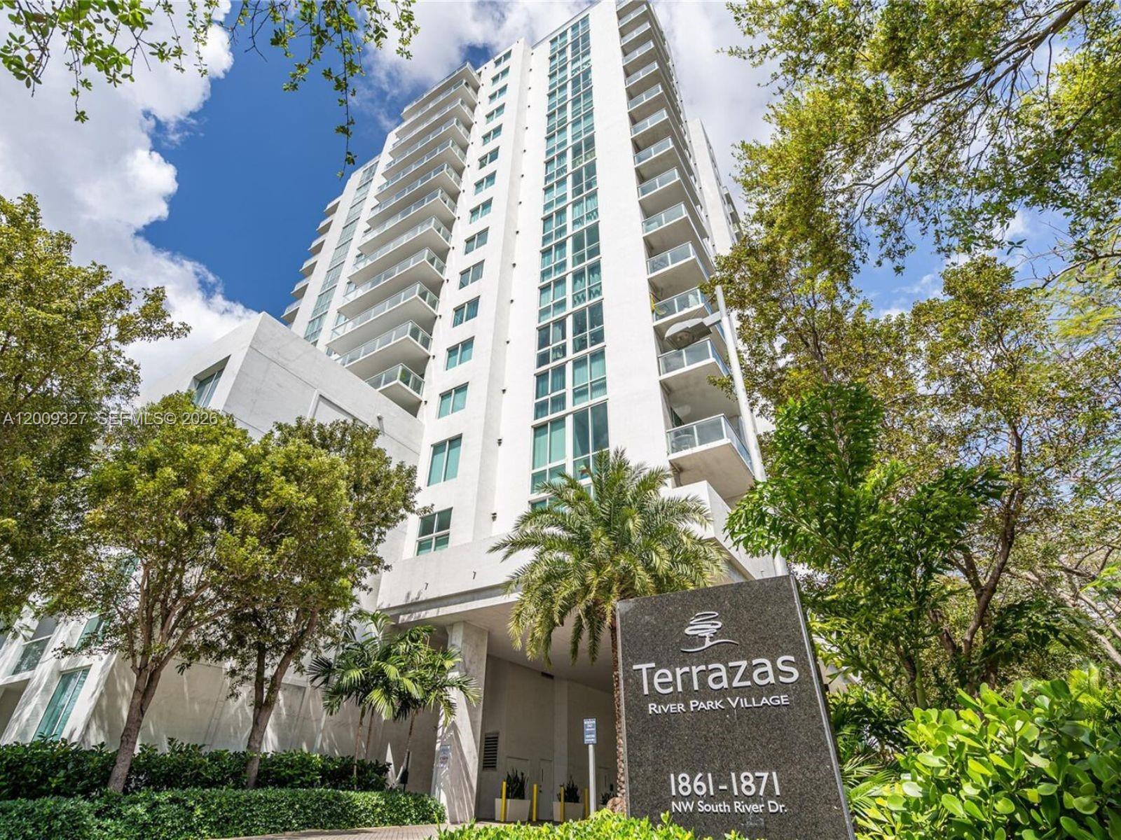 A tall white residential high-rise building surrounded by trees with a prominent entrance sign — 1861 NW S River Dr # 1408, Miami FL 33125, MIAMI, FL