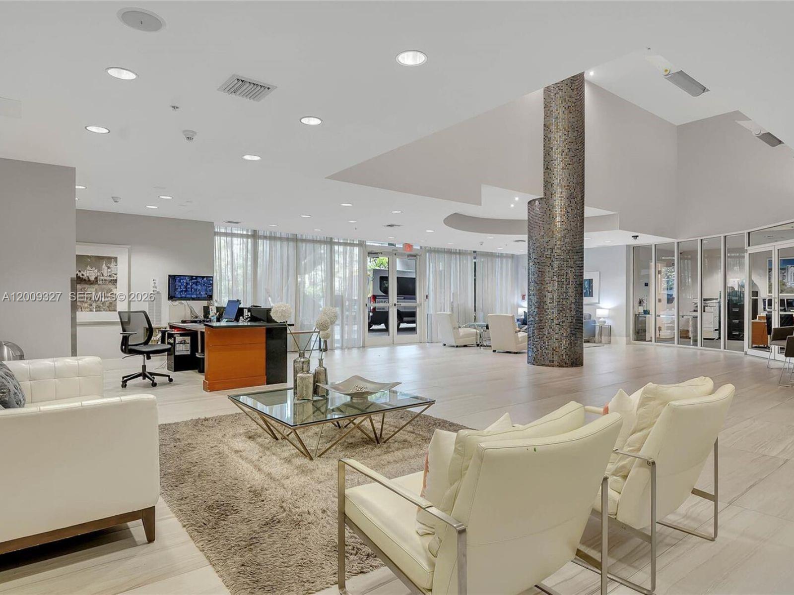 A modern lobby features a tiled floor, a mosaic-tiled column, and white leather seating — 1861 NW S River Dr # 1408, Miami FL 33125, MIAMI, FL