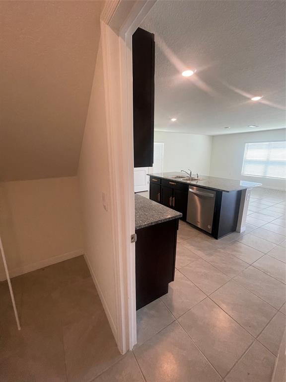 A view from a doorway into a kitchen with dark cabinets and a granite island — 35288 SPRUCE KNOB COURT, DADE CITY, FL