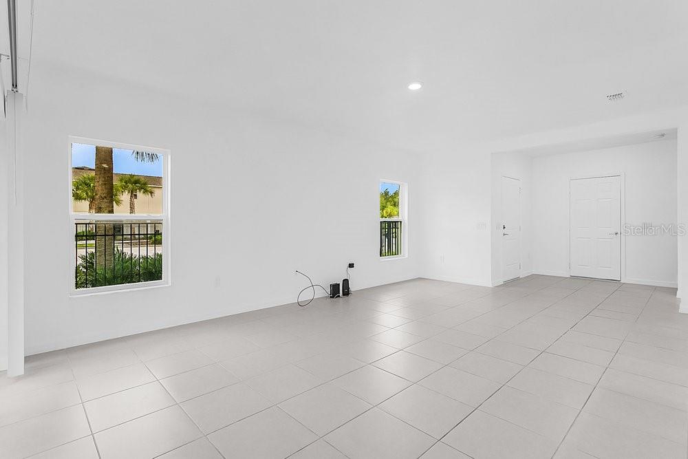 An empty room with white walls, light tile flooring, and two windows — 3401 BEAU ROAD, KISSIMMEE, FL