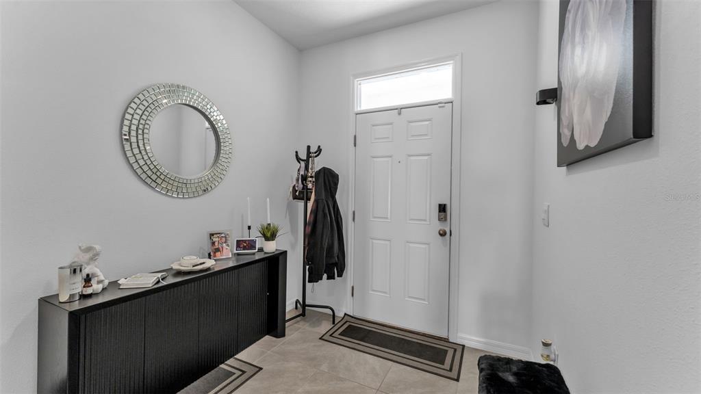 An entryway features a black console table, a round mirror, and a coat rack — 3532 WHITE DANDELION COURT, PLANT CITY, FL