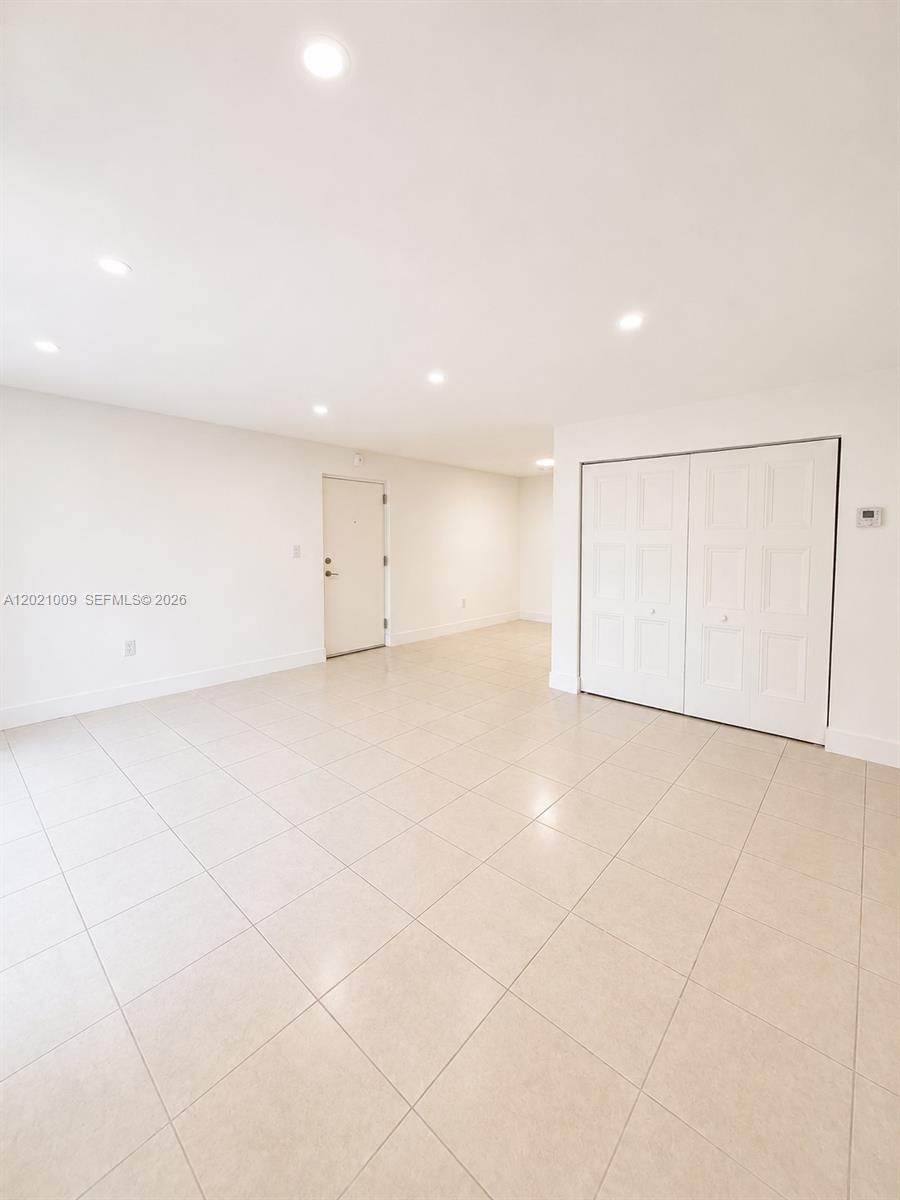 A bright, empty room features white walls, recessed lighting, tile flooring, and a white closet — 7160 Fairway Dr # J16, Miami Lakes FL 33014, MIAMI LAKES, FL
