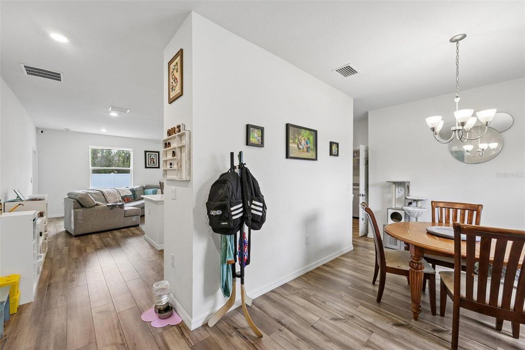A dining area and living room share an open floor plan with wood-look flooring — 4476 BLACKMAN STREET, NORTH PORT, FL