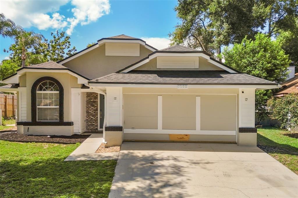 A single-story house with a beige stucco exterior, a two-car garage, and a front lawn — 1032 NIN STREET, ORLANDO, FL