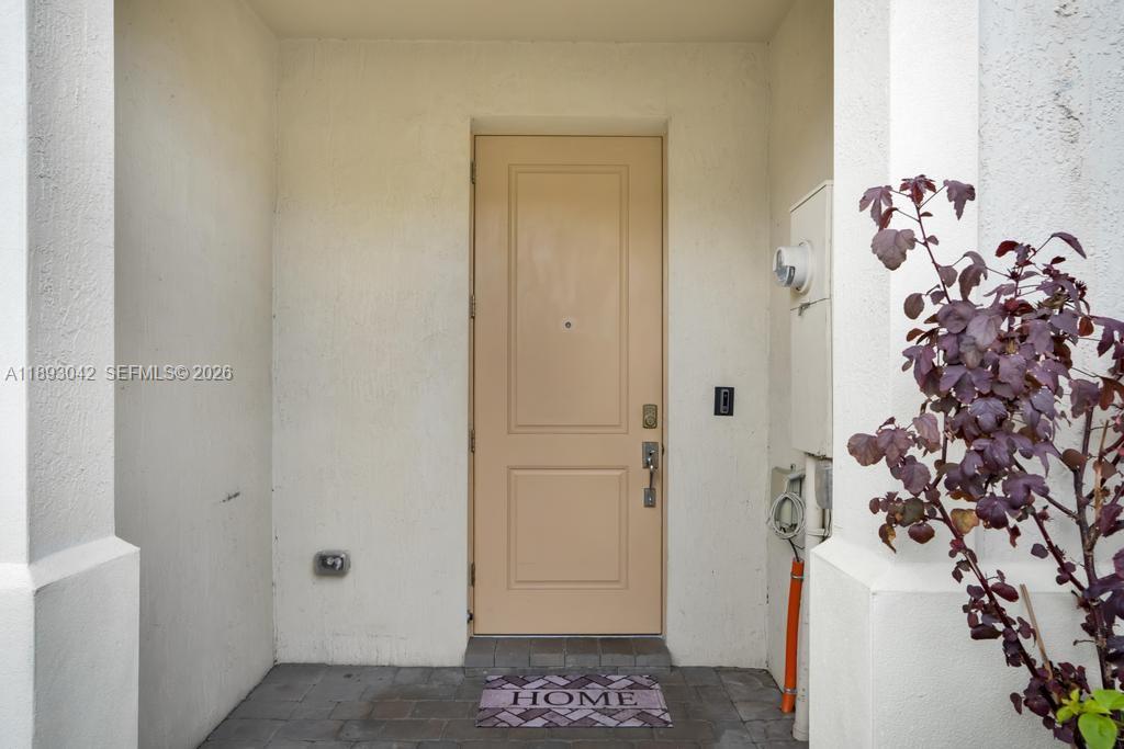 A beige front door with a welcome mat sits in a recessed entryway — 1422 Silk Oak Dr, Hollywood FL 33021, HOLLYWOOD, FL