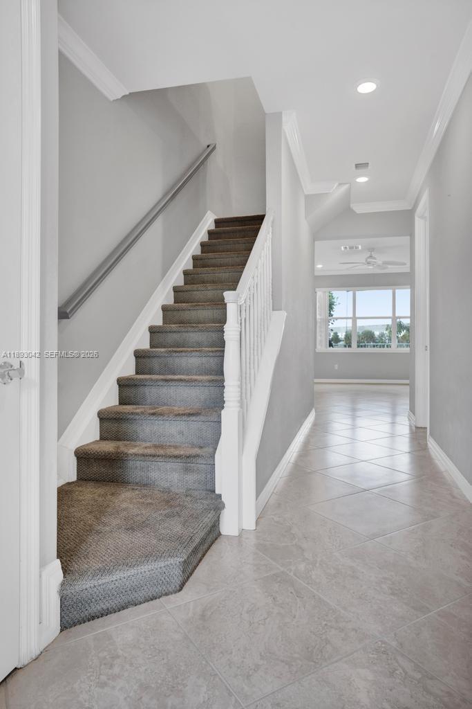 A carpeted staircase with a white railing leads to an upper floor in a hallway — 1422 Silk Oak Dr, Hollywood FL 33021, HOLLYWOOD, FL