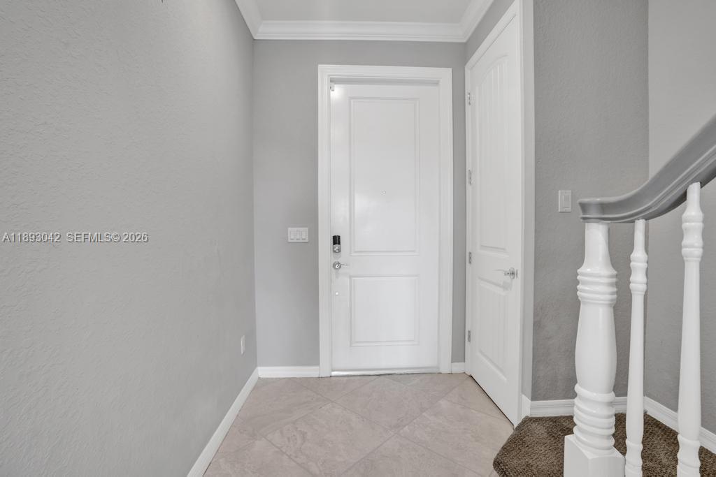 A bright entryway features a white front door, a side door, and a staircase railing — 1422 Silk Oak Dr, Hollywood FL 33021, HOLLYWOOD, FL