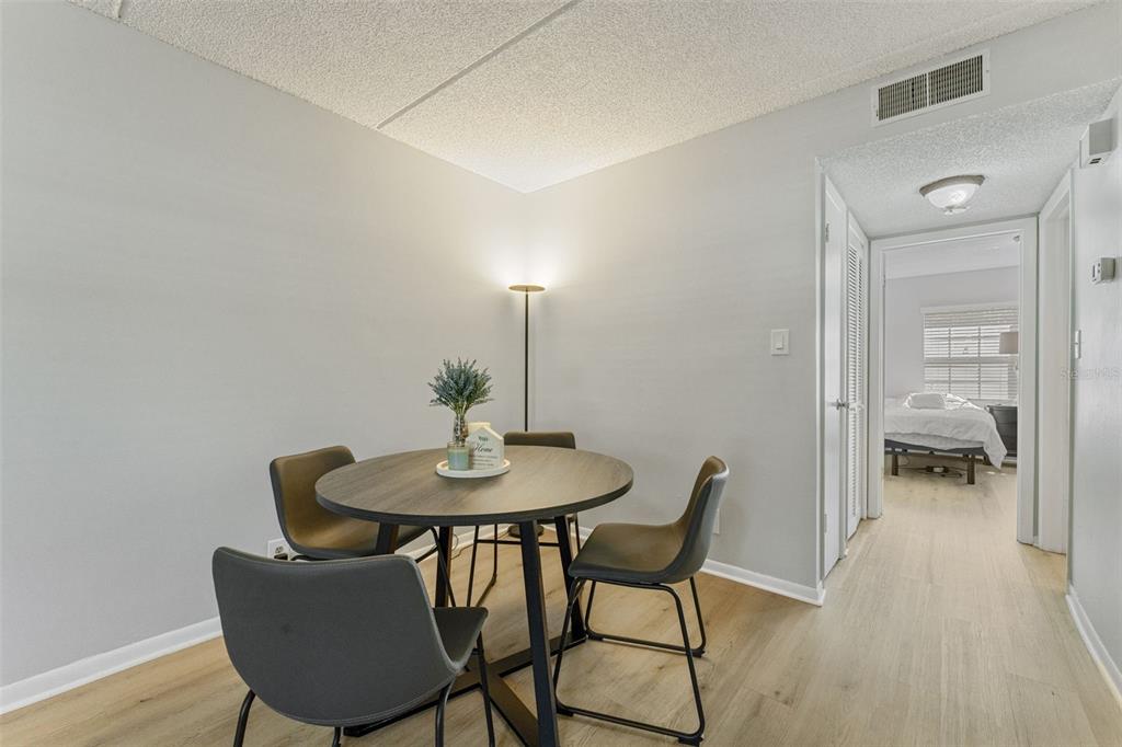 A dining area with a round table and four chairs sits next to a hallway — 4724 MICHAEL COURT UNIT 123, TAMPA, FL