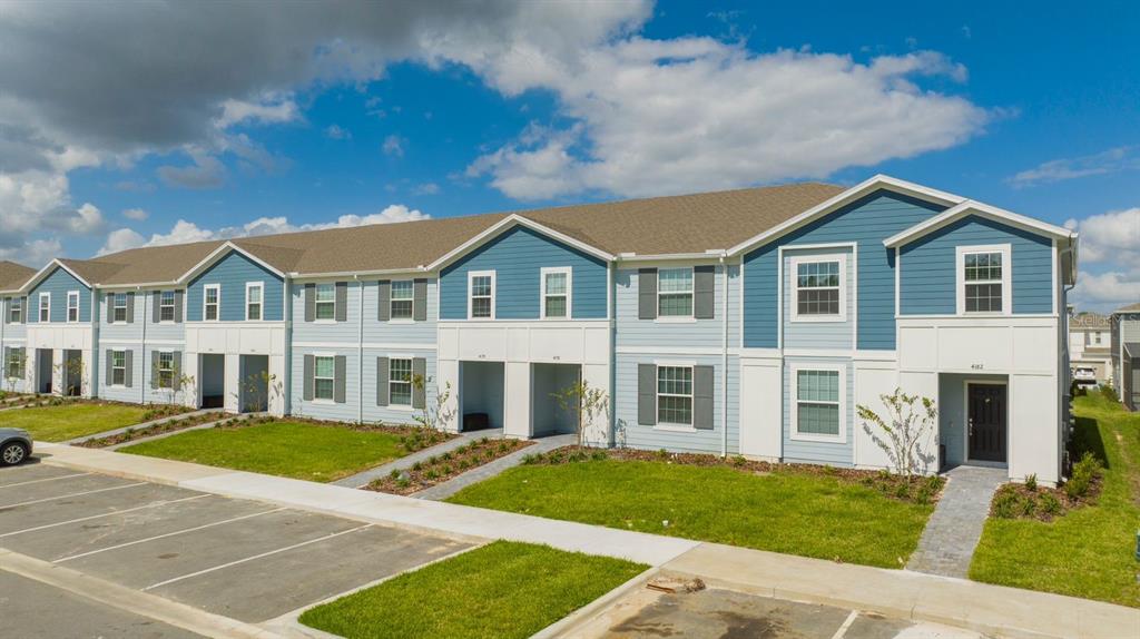 A multi-unit residential building with light blue siding and a brown shingled roof — 4178 LANA AVENUE, DAVENPORT, FL
