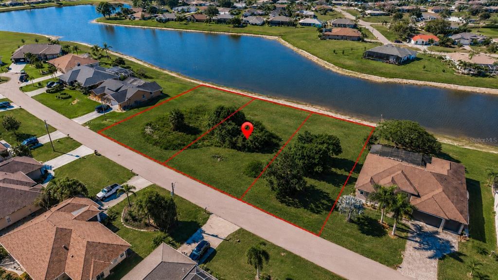 An aerial view shows three vacant waterfront lots outlined in red along a residential street — 2361 SOFIA LANE, PUNTA GORDA, FL