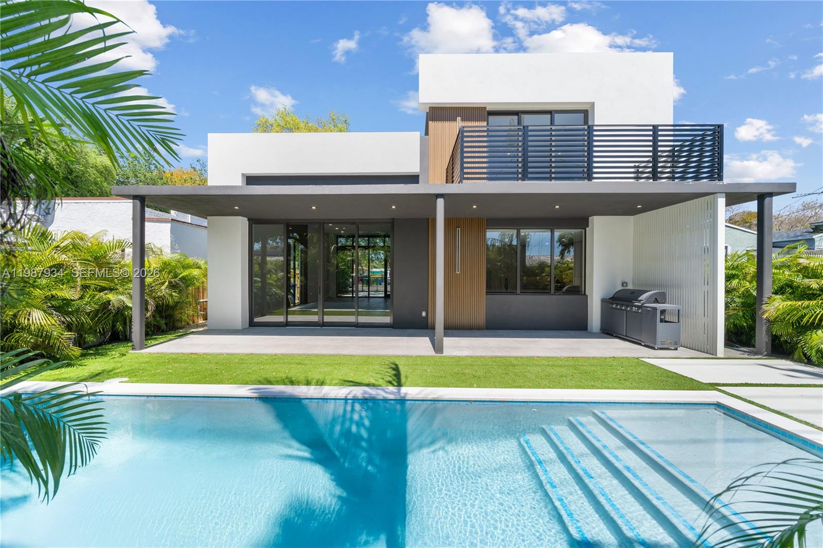 A modern two-story house features a patio, swimming pool, and a second-floor balcony — 536 NW 48th ST, Miami FL 33127, MIAMI, FL