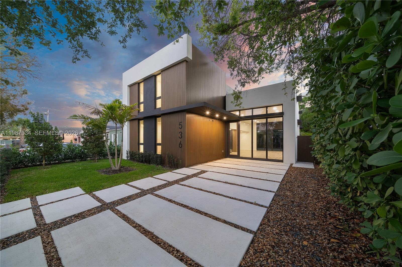 A modern two-story house features a slatted wood facade, white trim, and a concrete driveway — 536 NW 48th ST, Miami FL 33127, MIAMI, FL