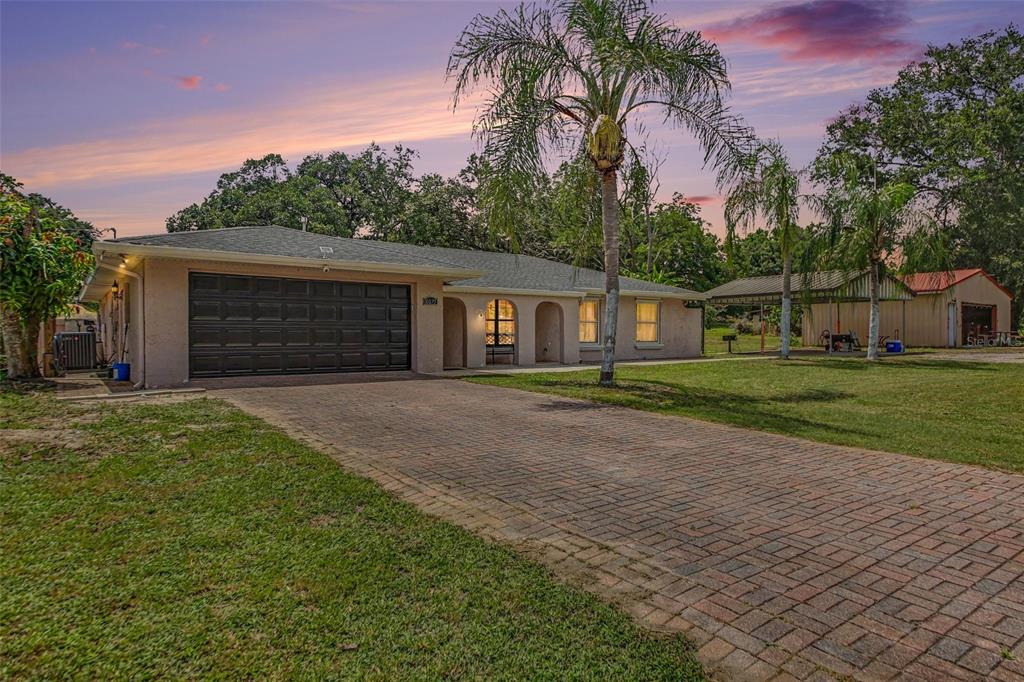 A single-story house with a brick driveway, a two-car garage, and a detached carport — 10073 LAKE MEADOW ROAD, APOPKA, FL