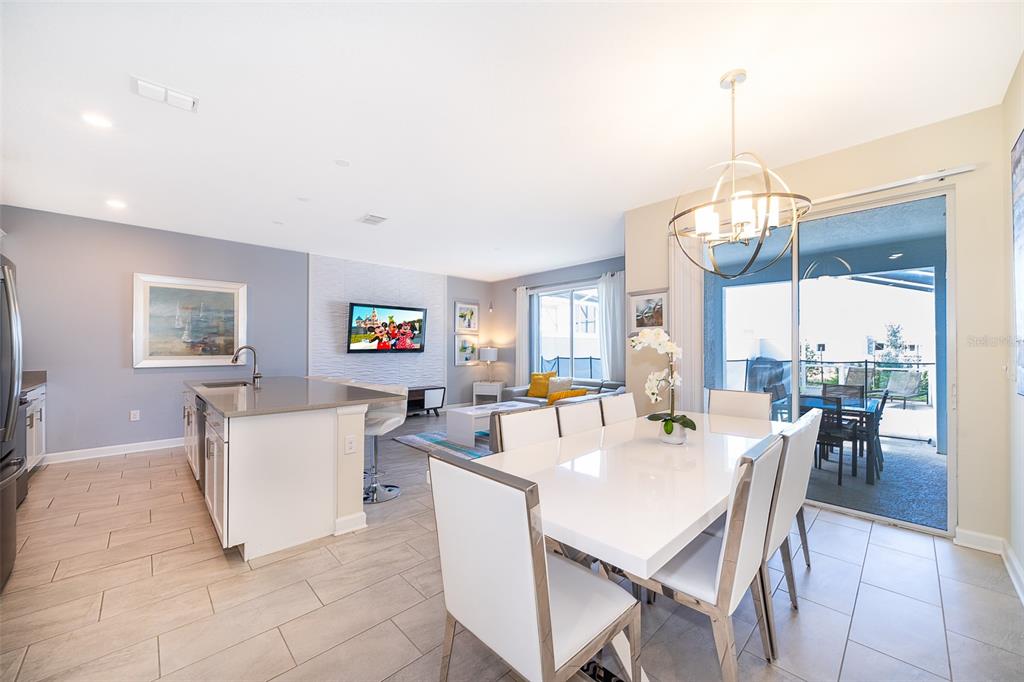 A dining area with a white table and chairs sits adjacent to a modern kitchen — 212 OCEAN COURSE AVENUE, DAVENPORT, FL