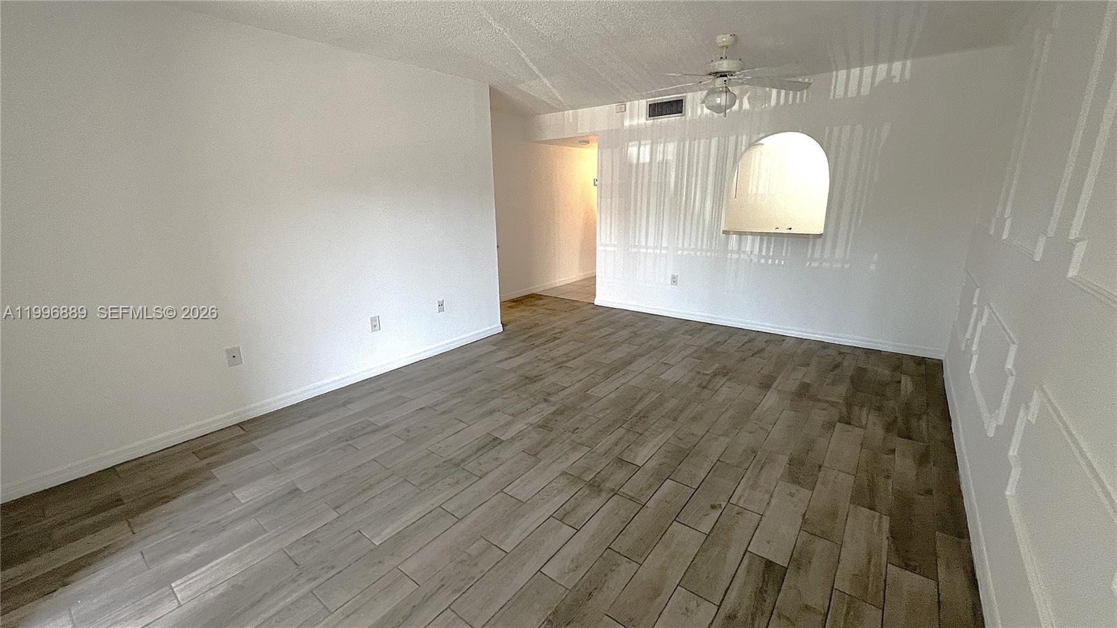 An empty room features wood-look tile flooring, white walls, and a ceiling fan — 711 N Pine Island Rd # 211, Plantation FL 33324, PLANTATION, FL