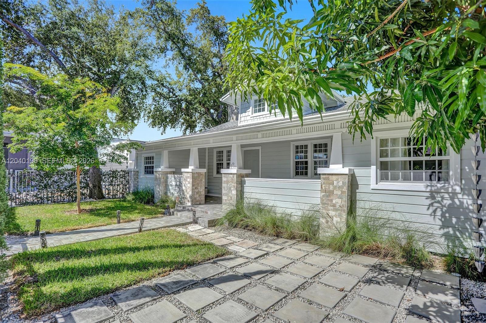 A light gray house features a stone-accented front porch and a paved stone walkway — 421 NE 70th ST, Miami FL 33138, MIAMI, FL