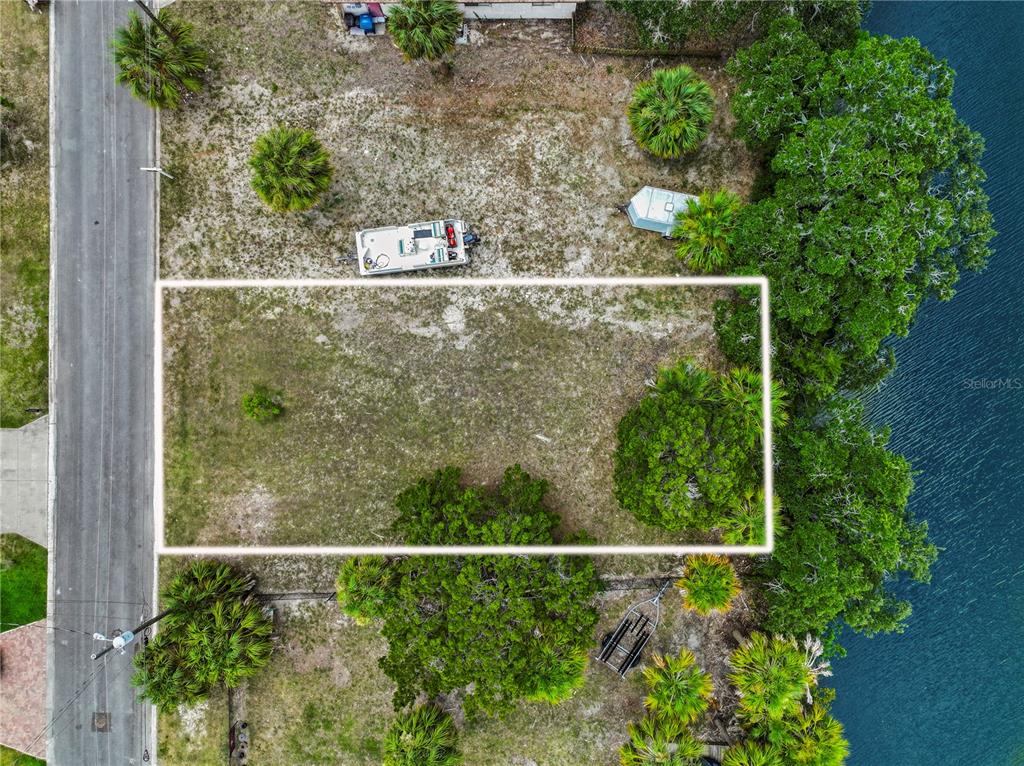 An aerial view shows a rectangular vacant lot bordered by a road and water — 3240 SEA GRAPE DRIVE, HERNANDO BEACH, FL