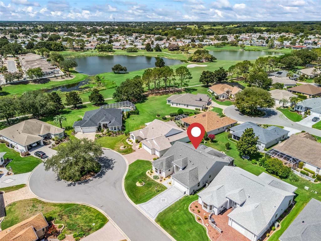 An aerial view shows a residential neighborhood with houses, a golf course, and a lake — 17946 SE 87TH MELROSE COURT, THE VILLAGES, FL