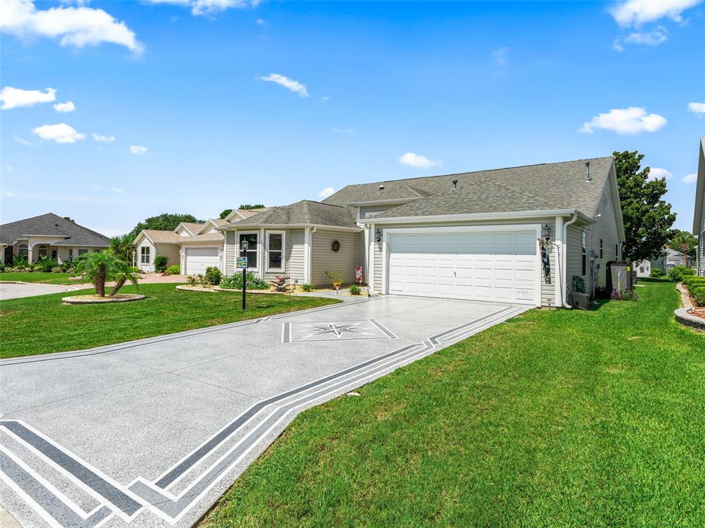 A single-story house with a decorative concrete driveway and a two-car garage — 17946 SE 87TH MELROSE COURT, THE VILLAGES, FL
