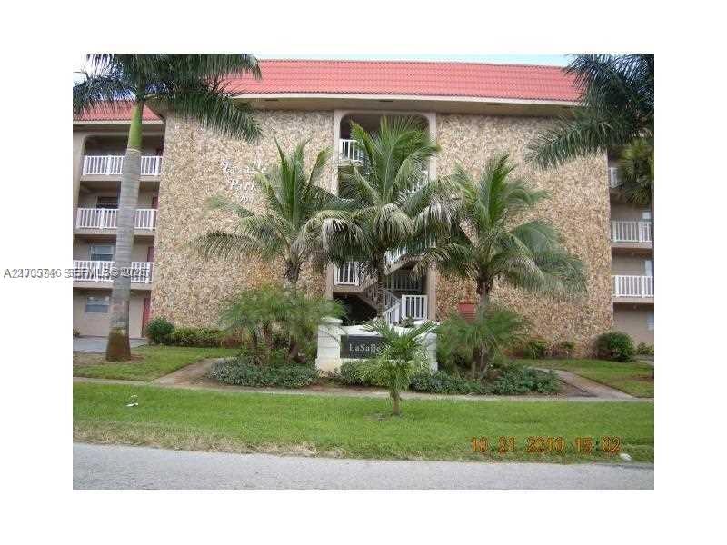 A multi-story apartment building with a stone facade, red roof, and palm trees in front — 1700 NW 58th Ter # 3M, Sunrise FL 33313, SUNRISE, FL