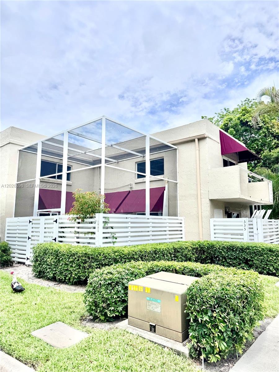 A two-story building features a screened-in patio, white fencing, and maroon awnings — 535 NW 98th Ave, Plantation FL 33324, PLANTATION, FL