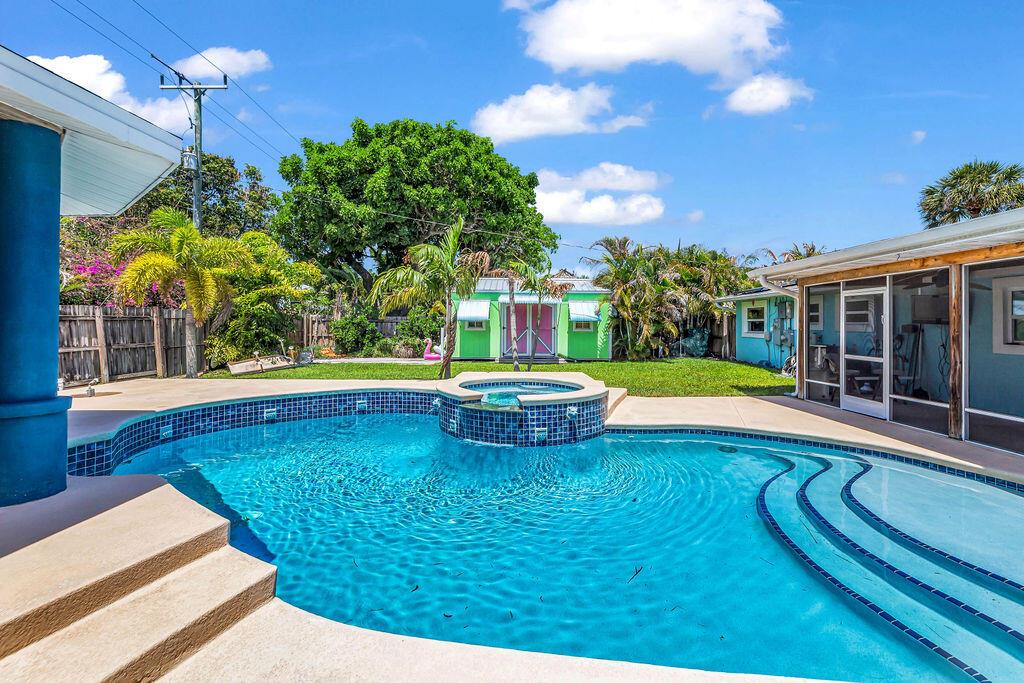 A backyard features a swimming pool with an integrated spa, patio, and a small shed — 614 SE Flamingo Avenue, Stuart FL 34996, STUART, FL