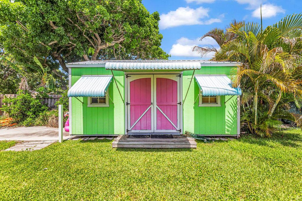 A kitchen with a breakfast bar, white cabinets, and a fireplace in the adjacent living area — 614 SE Flamingo Avenue, Stuart FL 34996, STUART, FL
