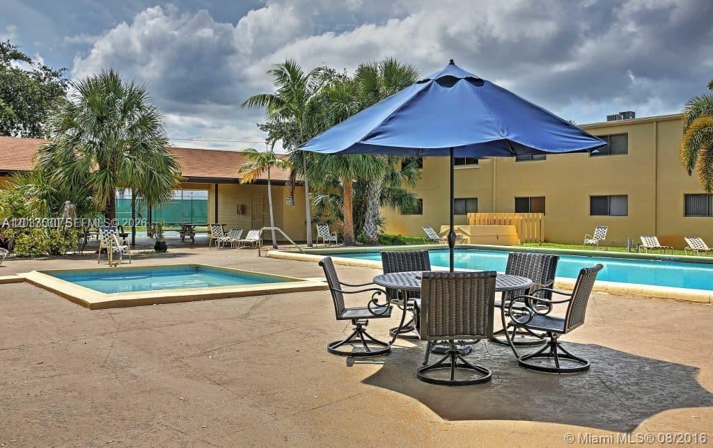 A patio area features a swimming pool, a hot tub, and a table with chairs — 1265 S Flagler Ave # 217, Pompano Beach FL 33060, POMPANO BEACH, FL