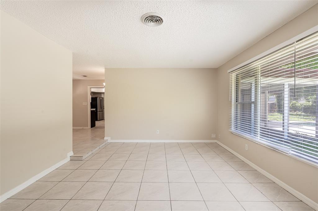 A bright dining room features light tile flooring, beige walls, and a large window — 806 HIGHLAND DRIVE, ALTAMONTE SPRINGS, FL