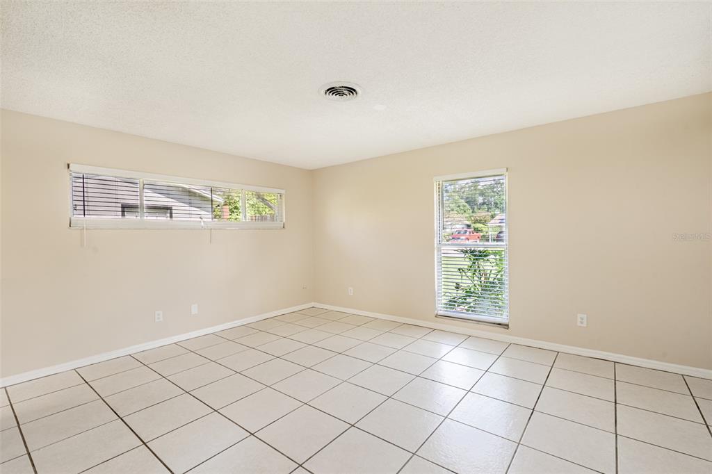 An empty room features beige walls, white tile flooring, and two windows with blinds — 806 HIGHLAND DRIVE, ALTAMONTE SPRINGS, FL