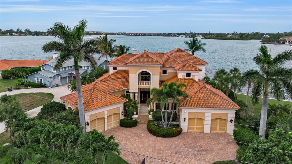 An aerial view of a waterfront Mediterranean-style house with a tile roof and paved driveway — 1541 CARIBBEAN DRIVE, SARASOTA, FL