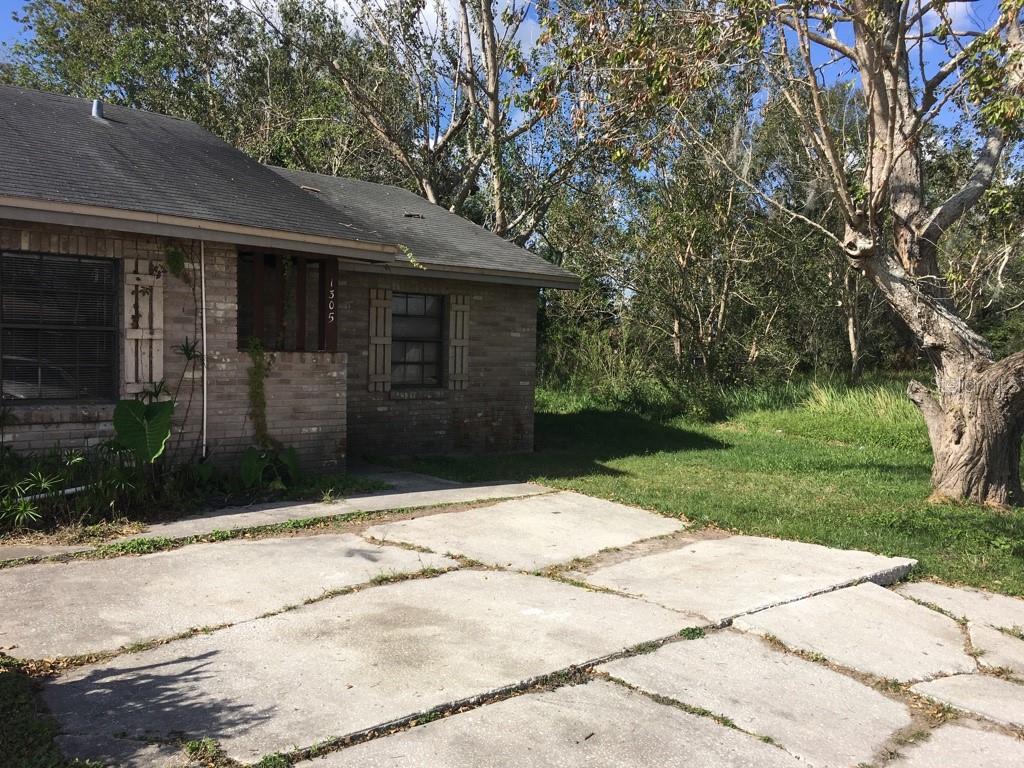 A brick house with a concrete driveway and a large tree in the front yard — 1305-1307 FAIRWAY DRIVE, LAKELAND, FL