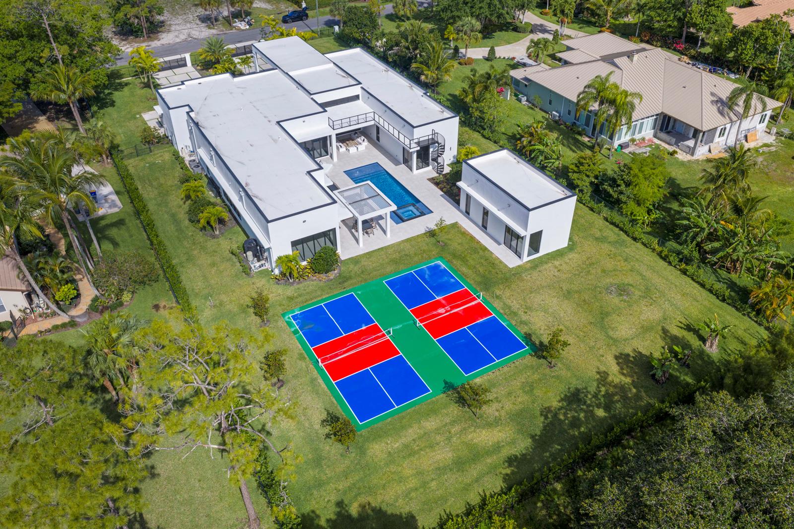 An aerial view shows a modern white house with a pool and two pickleball courts — 6676 NW 66th Way, Parkland FL 33067, PARKLAND, FL