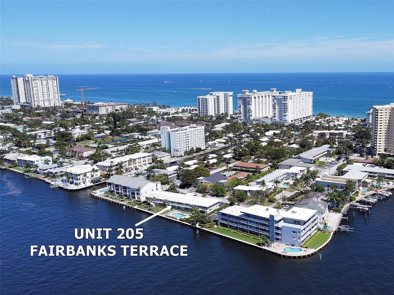 An aerial view shows a waterfront apartment complex with a swimming pool and docks — 1105 S Riverside Drive # 205, Pompano Beach FL 33062, POMPANO BEACH, FL