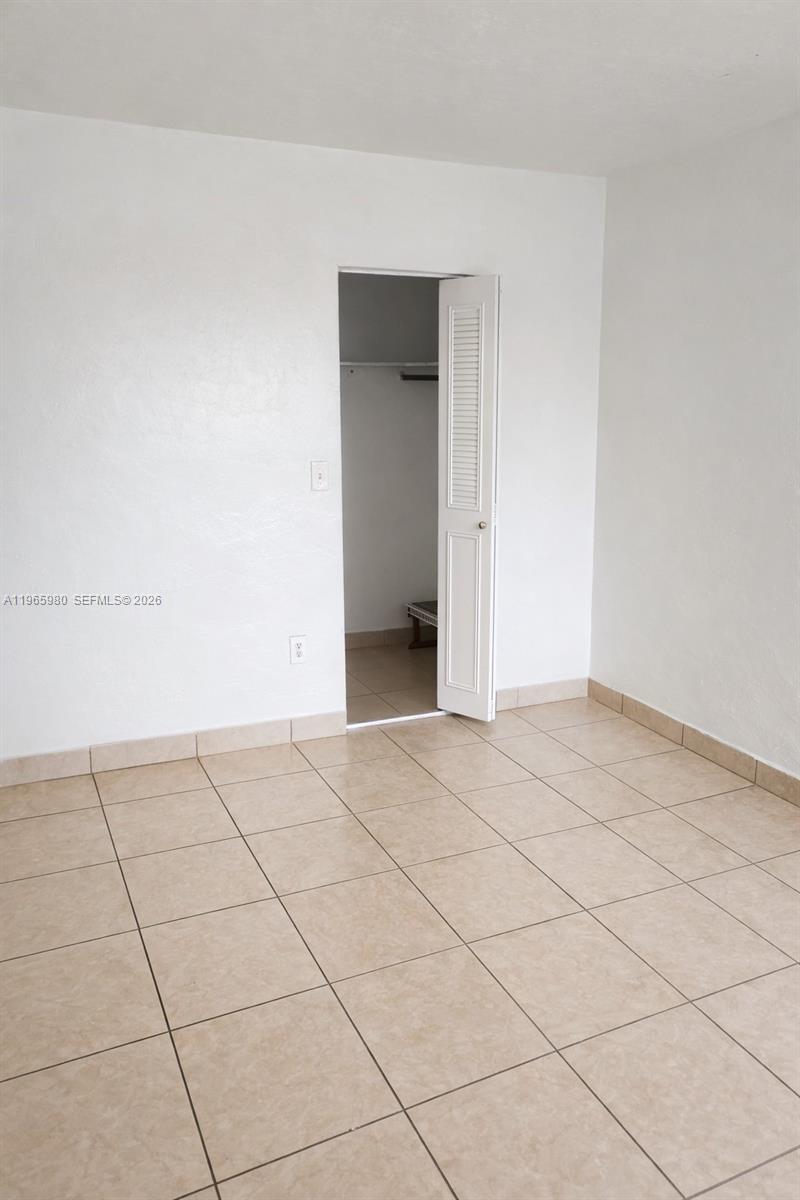 A room with light-colored tile flooring and an open closet door — 6850 W 14th Ct # A15, Hialeah FL 33014, HIALEAH, FL