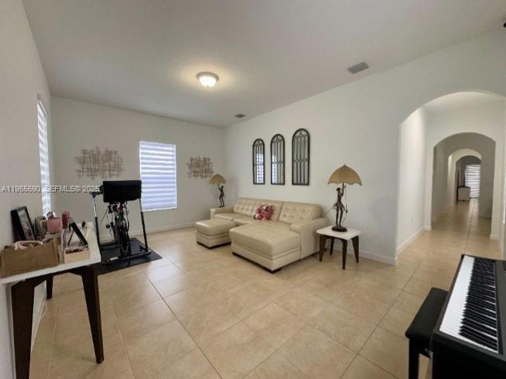 A living room features a beige sectional sofa, a stationary bike, and a piano — 17181 SW 91st St, Miami FL 33196, MIAMI, FL