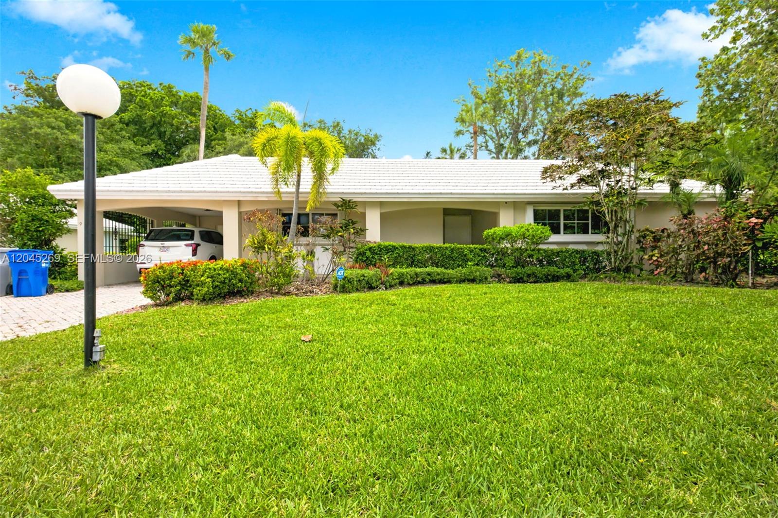 A single-story house with a white roof, a carport, and a manicured front lawn — 908 Cypress Ter # V57, Pompano Beach FL 33069, POMPANO BEACH, FL