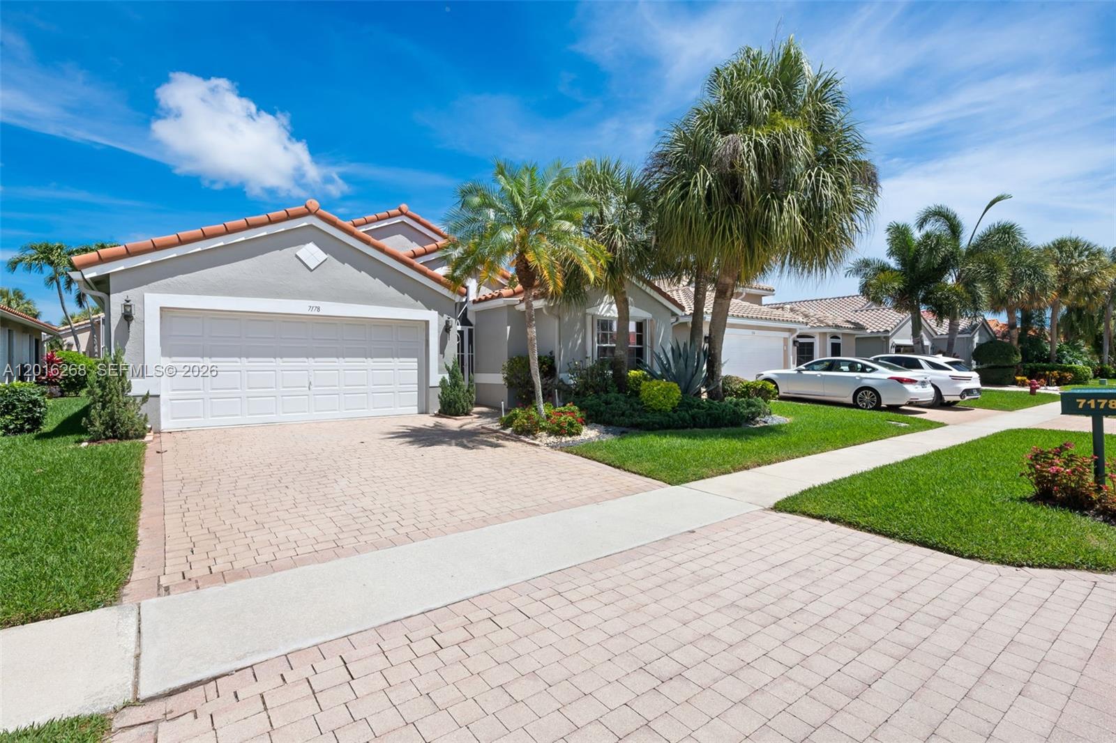 A single-story house with a paved driveway, palm trees, and a two-car garage — 7178 Haviland Circle, Boynton Beach FL 33437, BOYNTON BEACH, FL