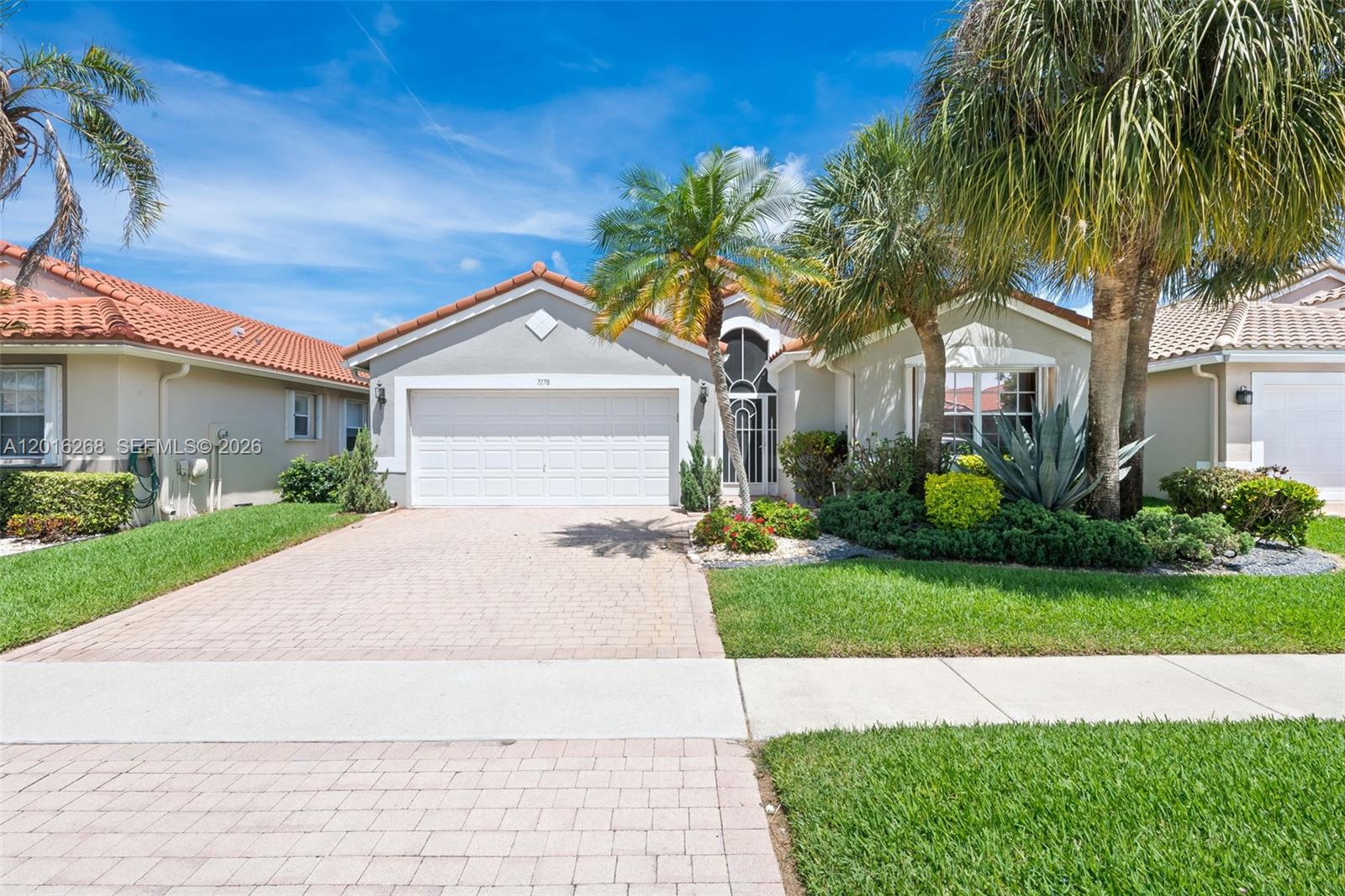 A single-story house with a paved driveway, a two-car garage, and palm trees in front — 7178 Haviland Circle, Boynton Beach FL 33437, BOYNTON BEACH, FL