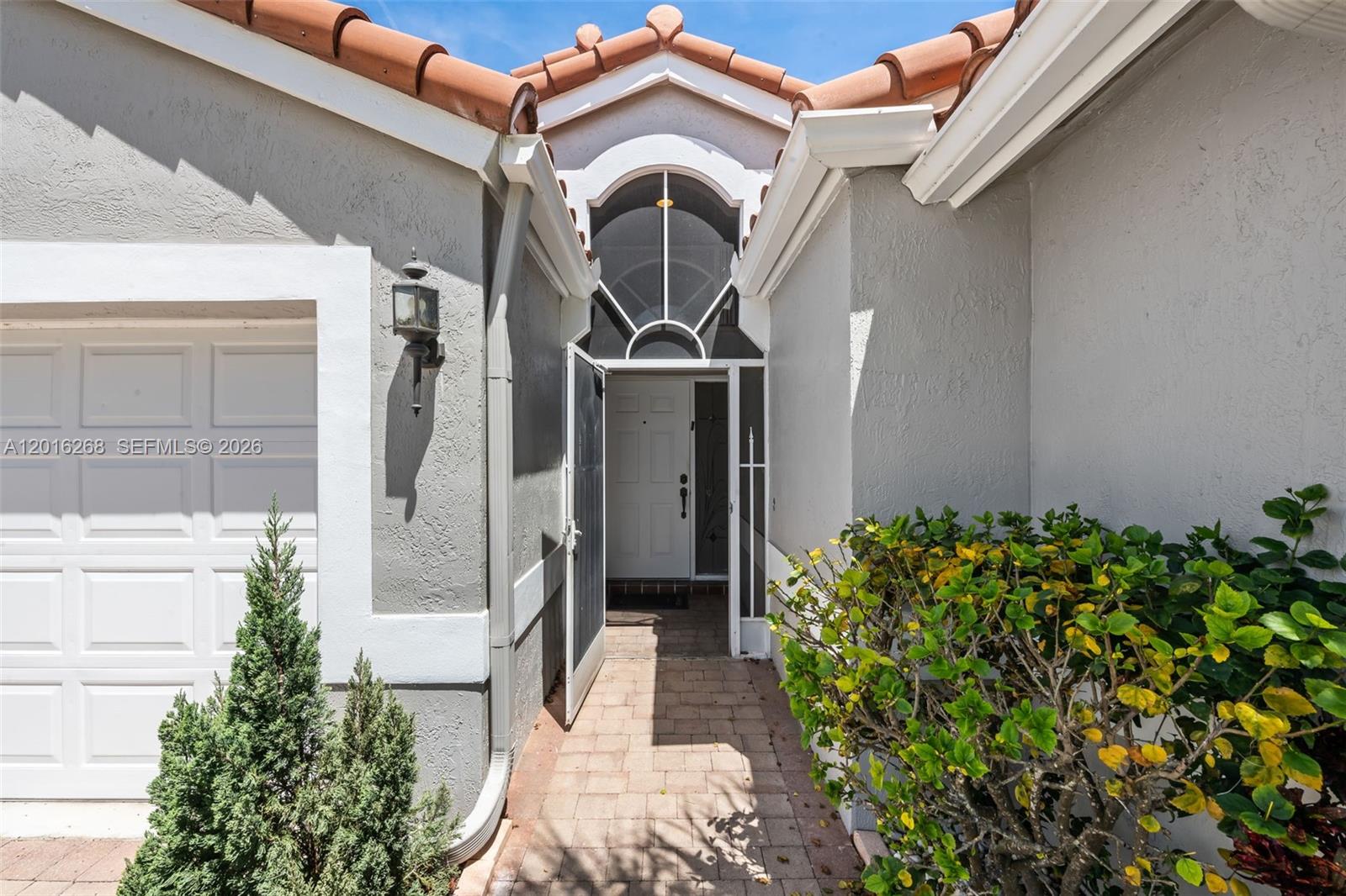 The exterior view shows a paved walkway leading to a white front door with a transom — 7178 Haviland Circle, Boynton Beach FL 33437, BOYNTON BEACH, FL