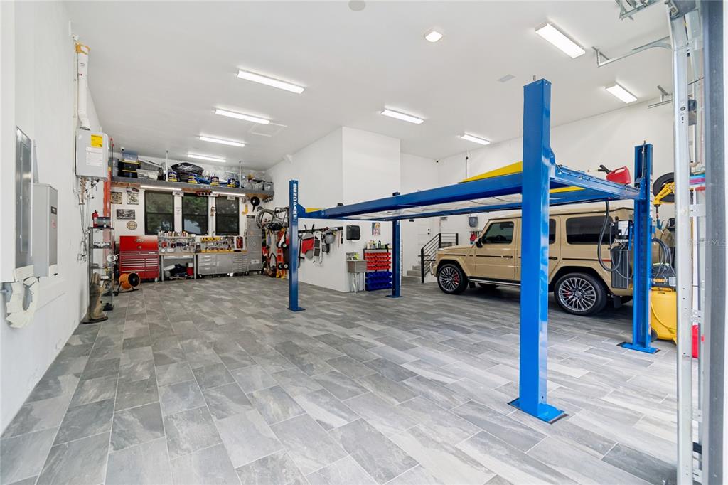 A tan Mercedes-Benz G-Wagon is parked inside a garage with a blue vehicle lift — 5410 BAYSHORE BLVD, TAMPA, FL