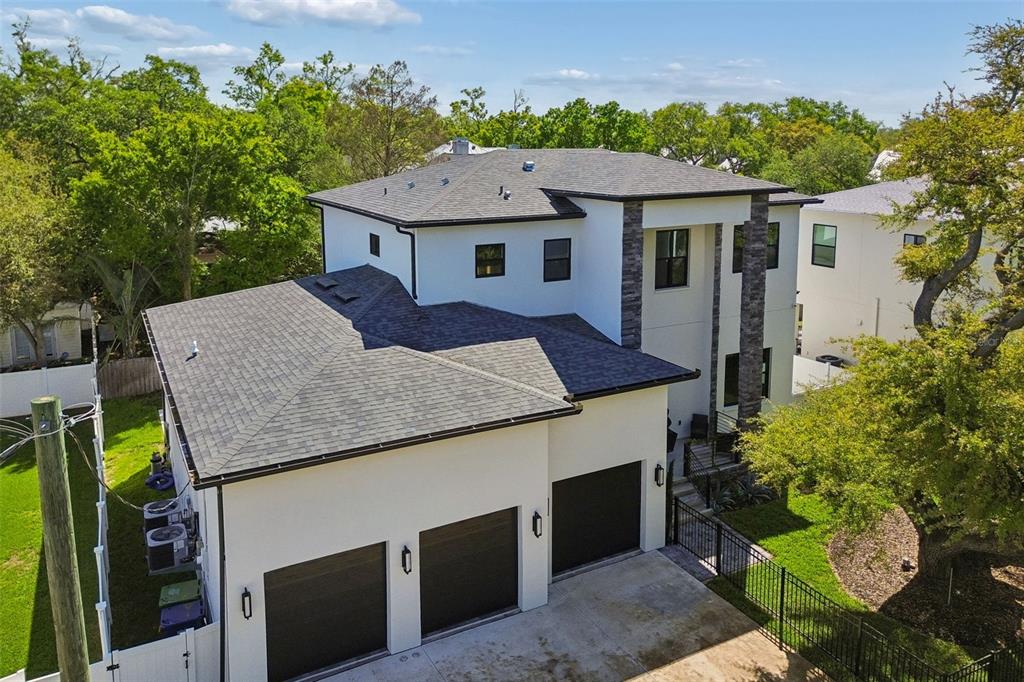 A garage with a blue four-post car lift, a light blue SUV, and tiled flooring — 5410 BAYSHORE BLVD, TAMPA, FL