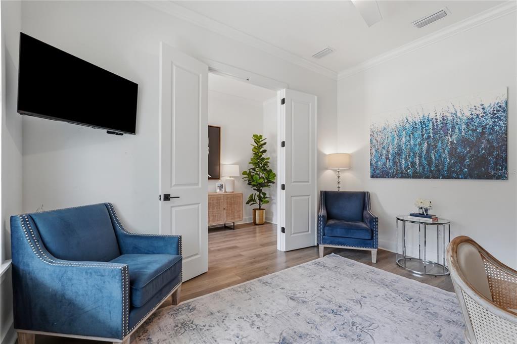 A room with two blue armchairs, a large abstract painting, and an open doorway — 4208 N CLEARFIELD AVENUE, TAMPA, FL