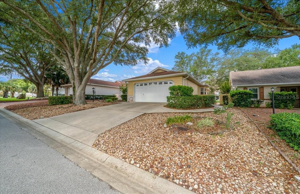 A yellow single-story house with a white garage door and a concrete driveway — 9040 SW 91ST TERRACE, OCALA, FL