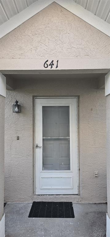 A front entryway features a white storm door, a house number, and a wall-mounted light — 641 KENSINGTON LAKE CIRCLE, BRANDON, FL