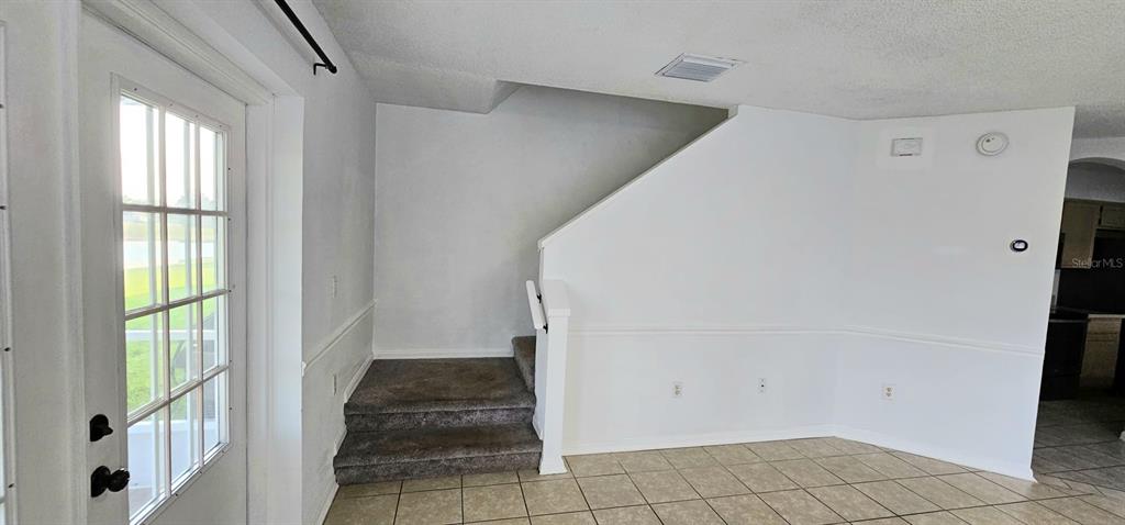 A room features a glass-paned door, carpeted stairs, and tiled flooring — 641 KENSINGTON LAKE CIRCLE, BRANDON, FL