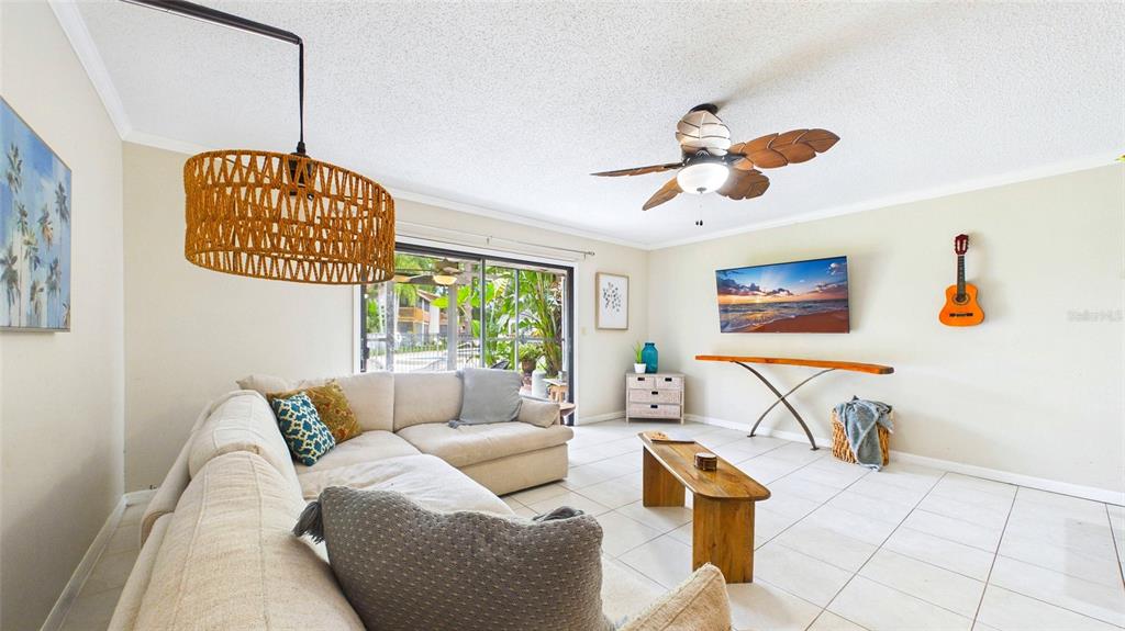 A living room features a sectional sofa, a wooden coffee table, and a wall-mounted television — 2122 TARPON LANDINGS DRIVE, TARPON SPRINGS, FL
