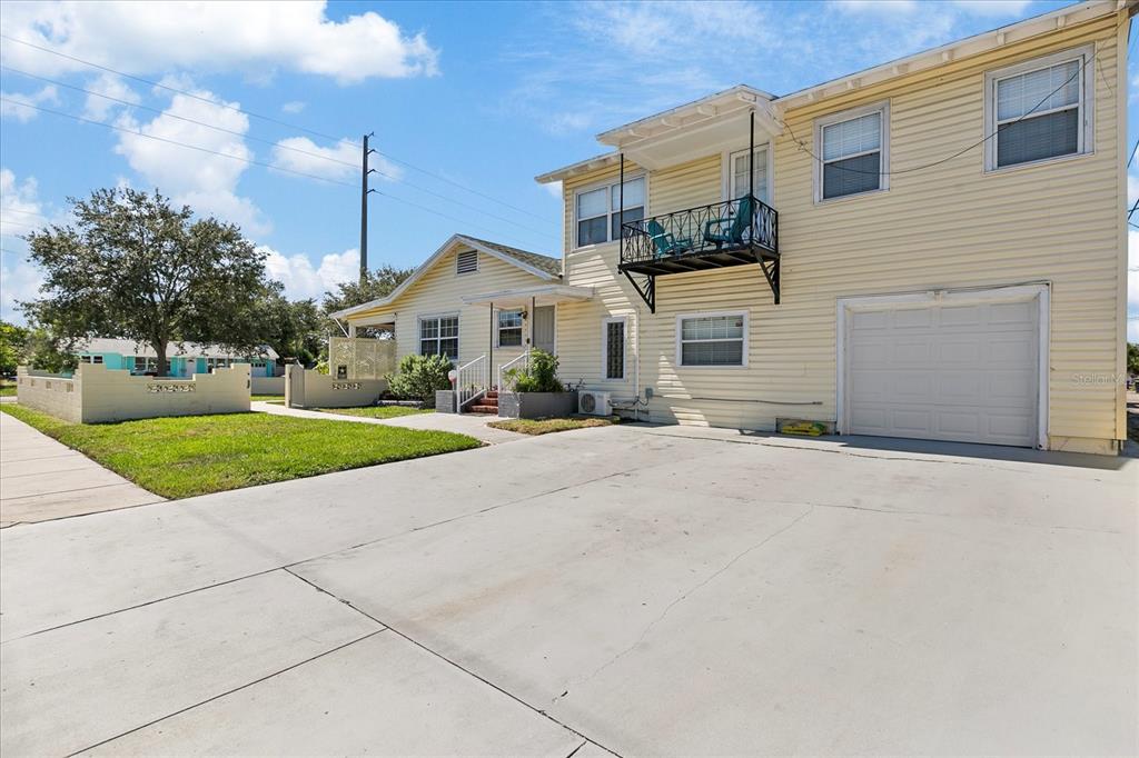 A two-story yellow house with a concrete driveway, a balcony, and a garage — 3801 1ST AVENUE S, ST PETERSBURG, FL